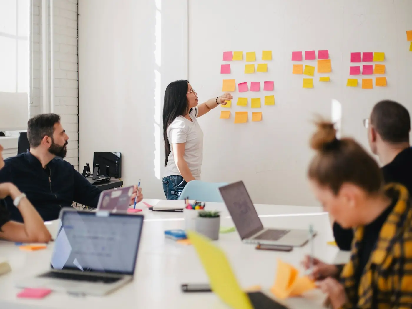 A designer mapping ideas on sticky notes during a team workshop